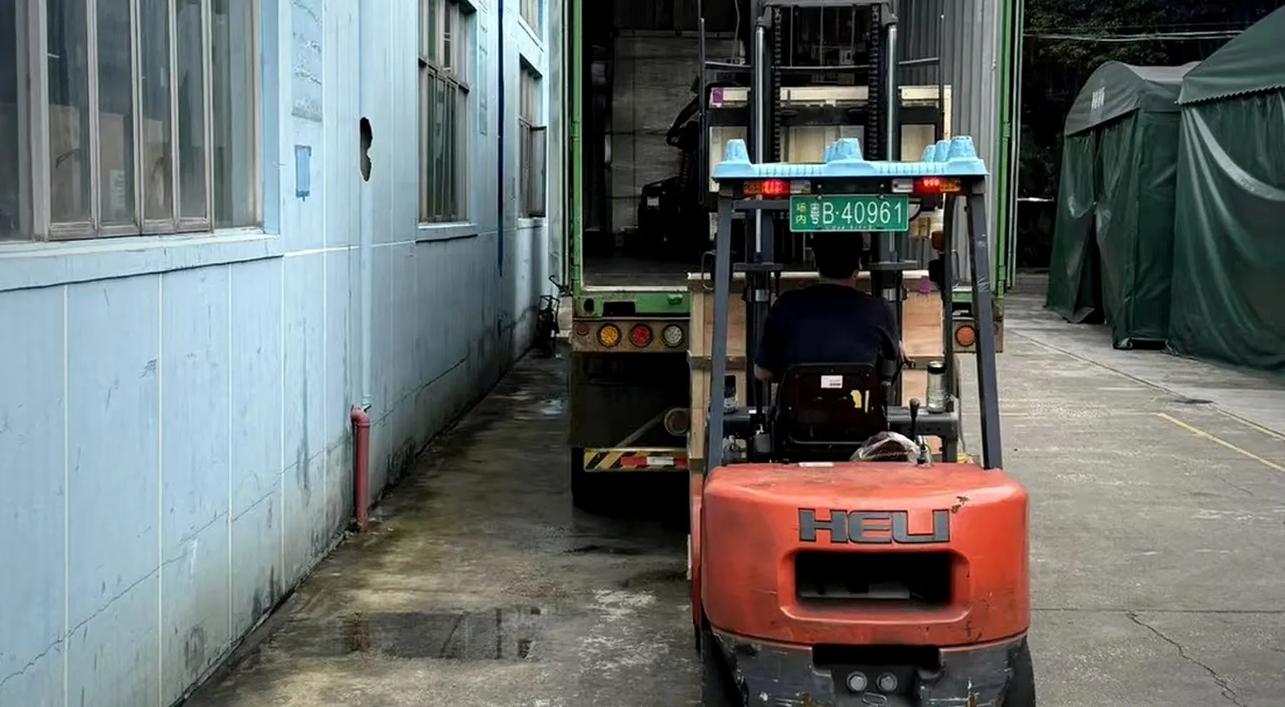 Forklift loading bulky cargo into a container