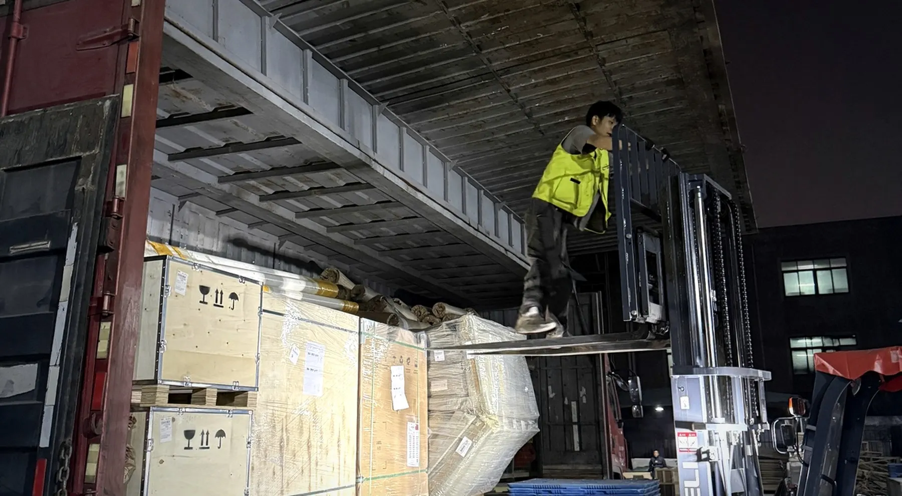 Night loading site with wooden-crated cargo ready for dispatch