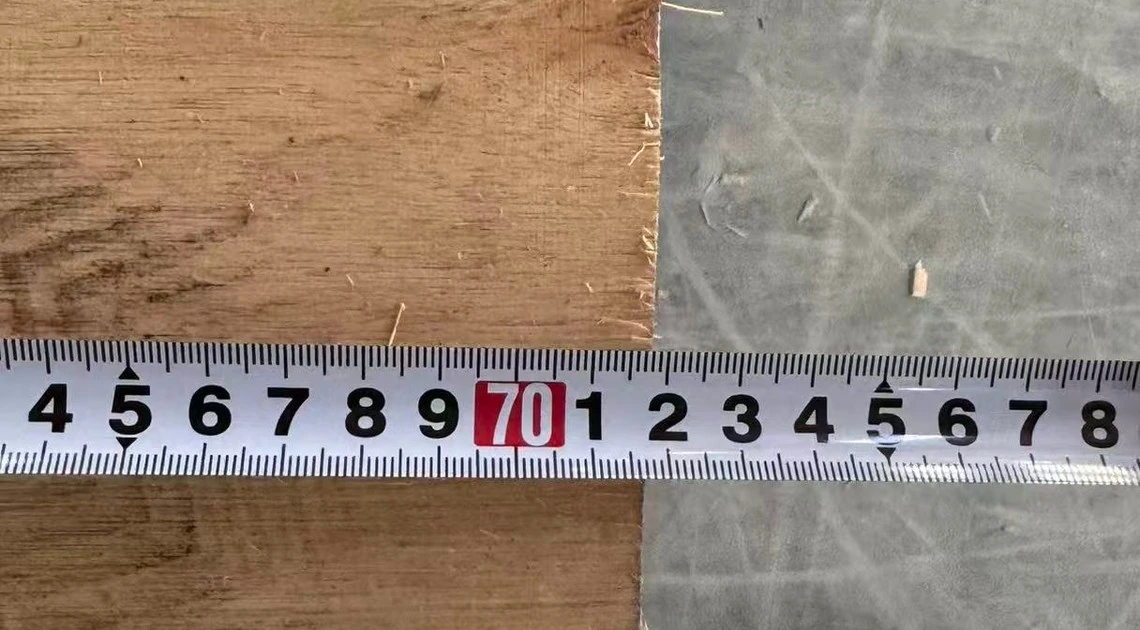 Ruler photograph across the width of an anonymized wooden crate