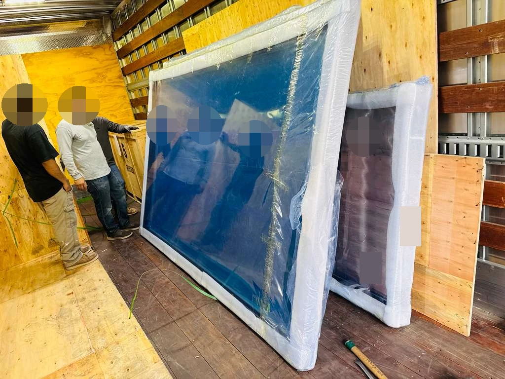 Glass panels visible inside the delivery vehicle; faces, reflections and identifying marks obscured